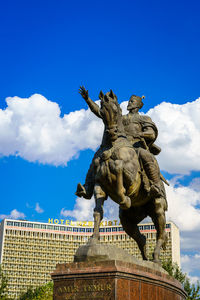 Low angle view of statue against blue sky