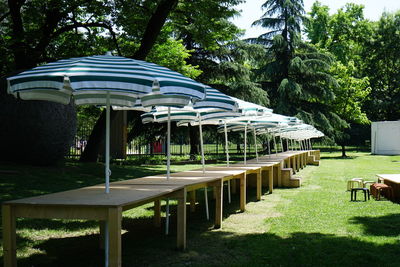 Empty benches in park against sky