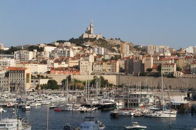 Sailing boats at harbor and church notre-dame de la garde in background