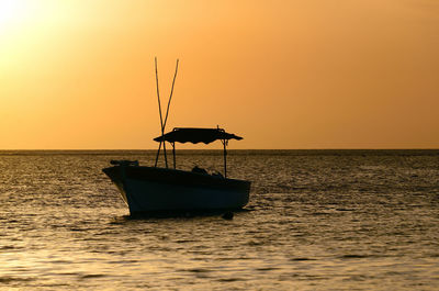 Sailboat in sea against sky during sunset