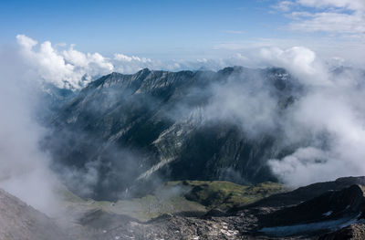 Scenic view of mountain range against cloudy sky