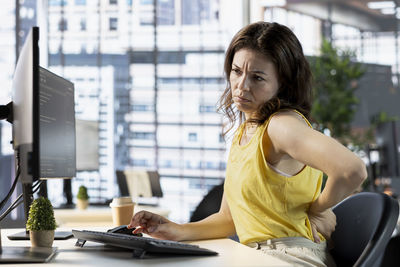 Portrait of young woman using laptop at home