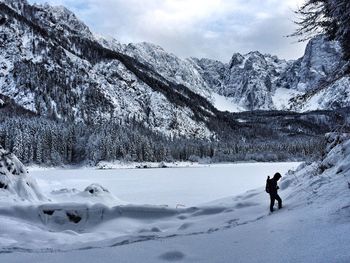 Man on snow covered land against sky