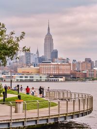 People in city against cloudy sky