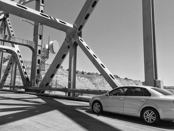 Cars on bridge against sky in city