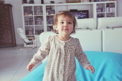 Portrait of cute girl standing at home