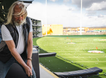 Senior man playing golf in modern golf location