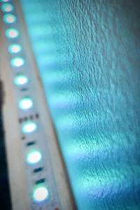 Low angle view of illuminated lighting equipment on wall