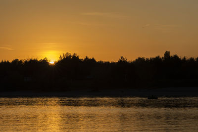 Scenic view of lake against orange sky