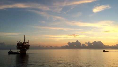 Boat in sea at sunset