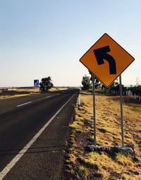 Road sign against clear sky