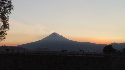 Scenic view of mountains against clear sky during sunset