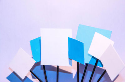 High angle view of multi colored paper against white background