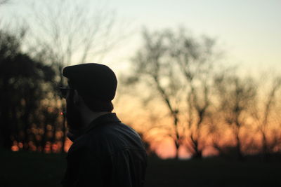 Rear view of silhouette man standing against sky during sunset