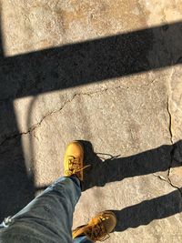 Low section of man standing on tiled floor