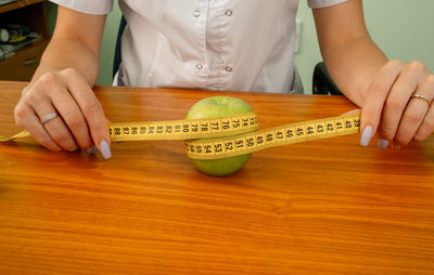 Green apple measured the meter in a female hand.