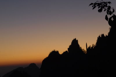 Silhouette trees against clear sky during sunset