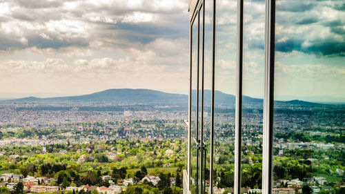 Trees and cityscape against sky