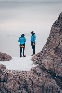 Rear view of people on rock against sky