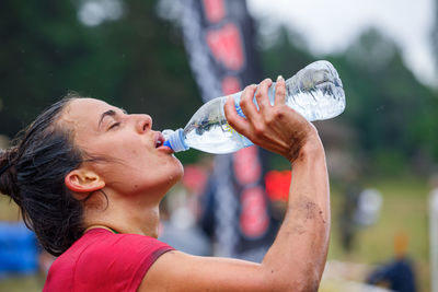 Midsection of woman drinking water from bottle