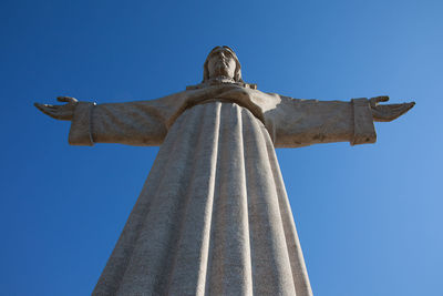 Low angle view of statue against blue sky