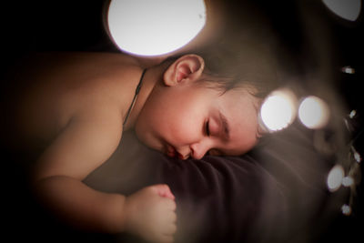 High angle view of cute baby girl sleeping on bed at home