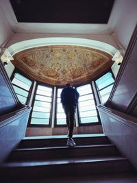 Rear view of woman standing on staircase