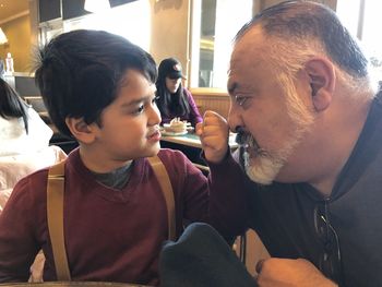 Portrait of father and daughter sitting in office