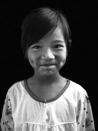 Portrait of smiling girl against black background