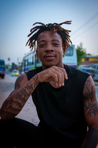 Portrait of smiling young man sitting outdoors 