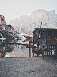 Stilt house by lake against mountain