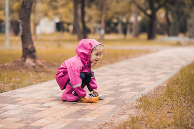 Cute girl playing with paper boat at park