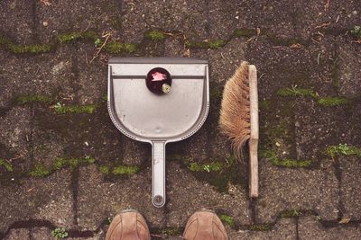 Man standing in front of dustpan and brush on footpath