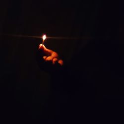Person holding burning candle