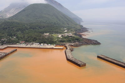 High angle view of sea and mountains against sky