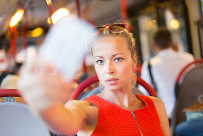 Portrait of beautiful woman taking selfie sitting at bus