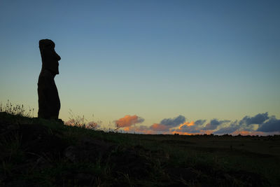 Silhouette moai statue against sky during sunset