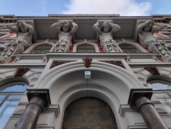 Low angle view of statues on building against sky