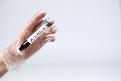 Close-up of hand holding hands over white background