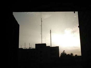 Silhouette of city against sky during sunset