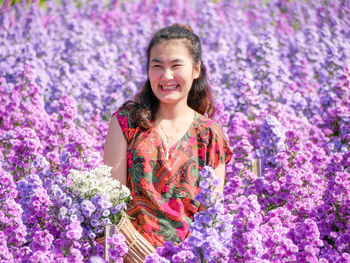 Portrait of a smiling woman standing on field