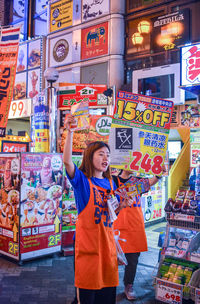 Full length of a smiling young woman standing in store