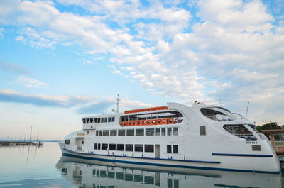 Ship moored on pier by sea against sky