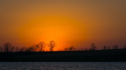 Scenic view of lake against orange sky