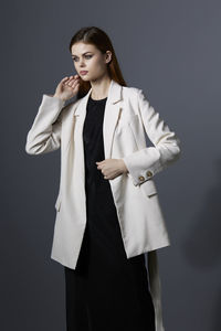 Young woman standing against black background