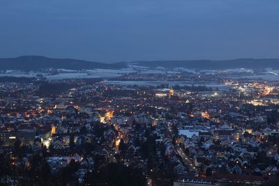 High angle view of illuminated cityscape against sky at dusk