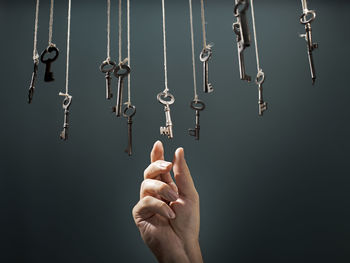 Close-up of hand hanging against black background