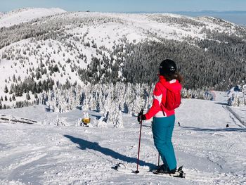 Full length of woman skiing on snowcapped mountain