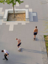 High angle view of friends skateboarding on street