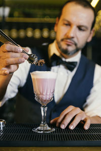 Bartender making drink on counter in bar